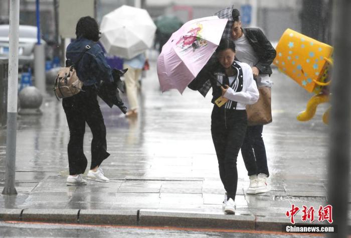 资料图:市民顶风冒雨出行. 中新社记者 张瑶 摄
