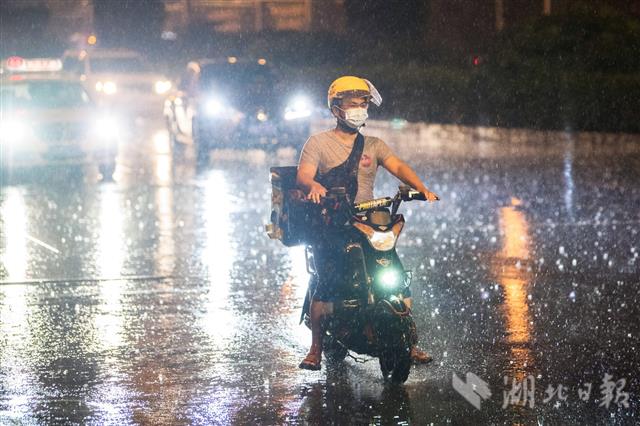 武汉快递小哥风雨中奔忙