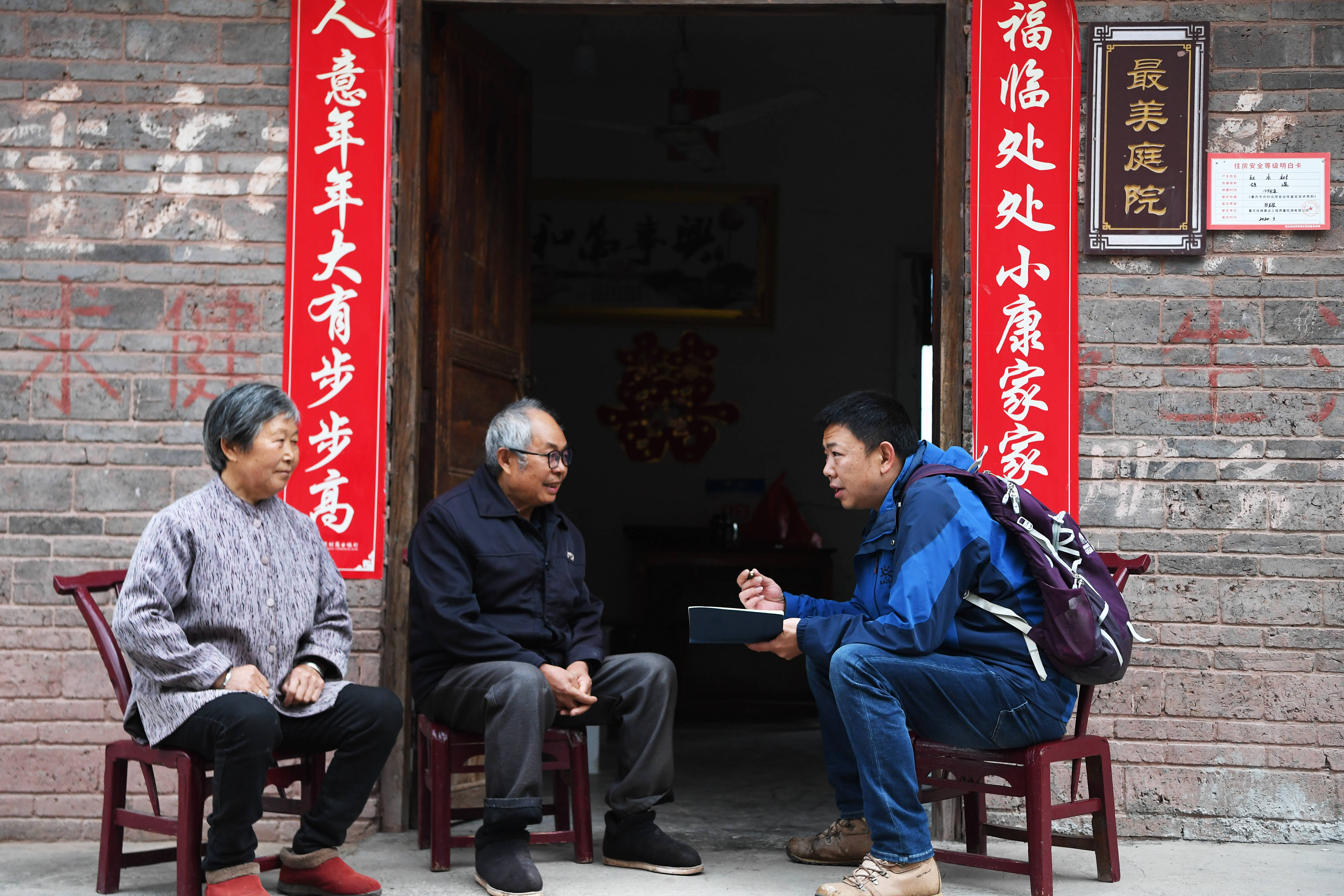 3月30日,王涛(右)与村民赵长庆(中,刘昌菊夫妇交谈.