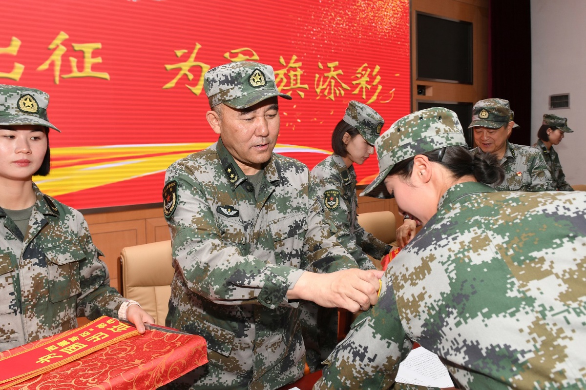 西藏军区司令员王凯为参赛队员贴上国旗