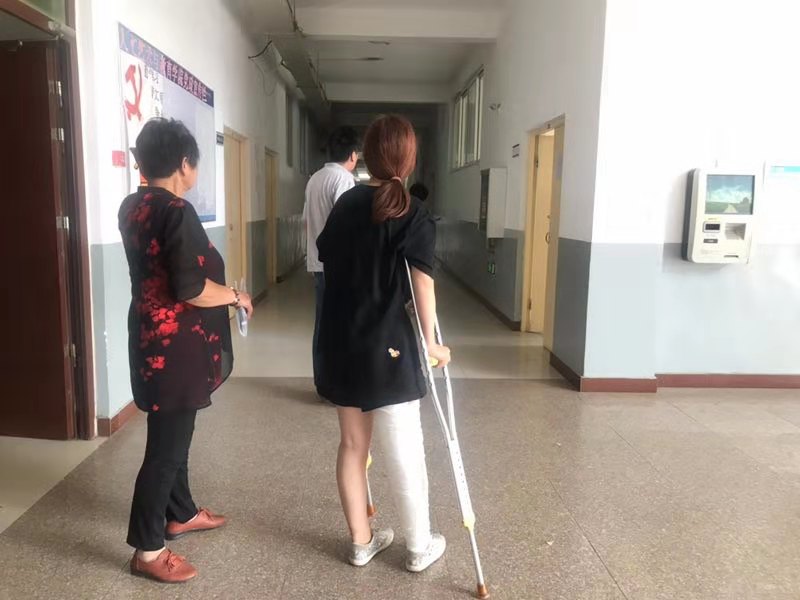 这位女生右腿受伤严重,只能拄拐行走.