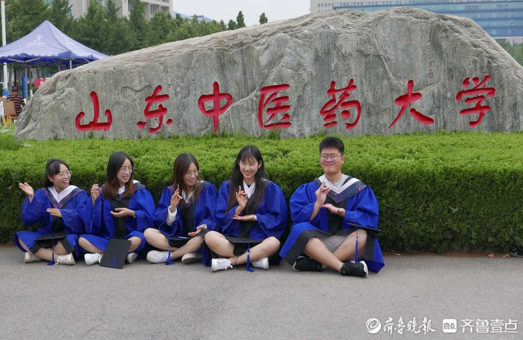 6月24日,山东中医药大学大门口,该校生化专业周教授的毕业生们穿起
