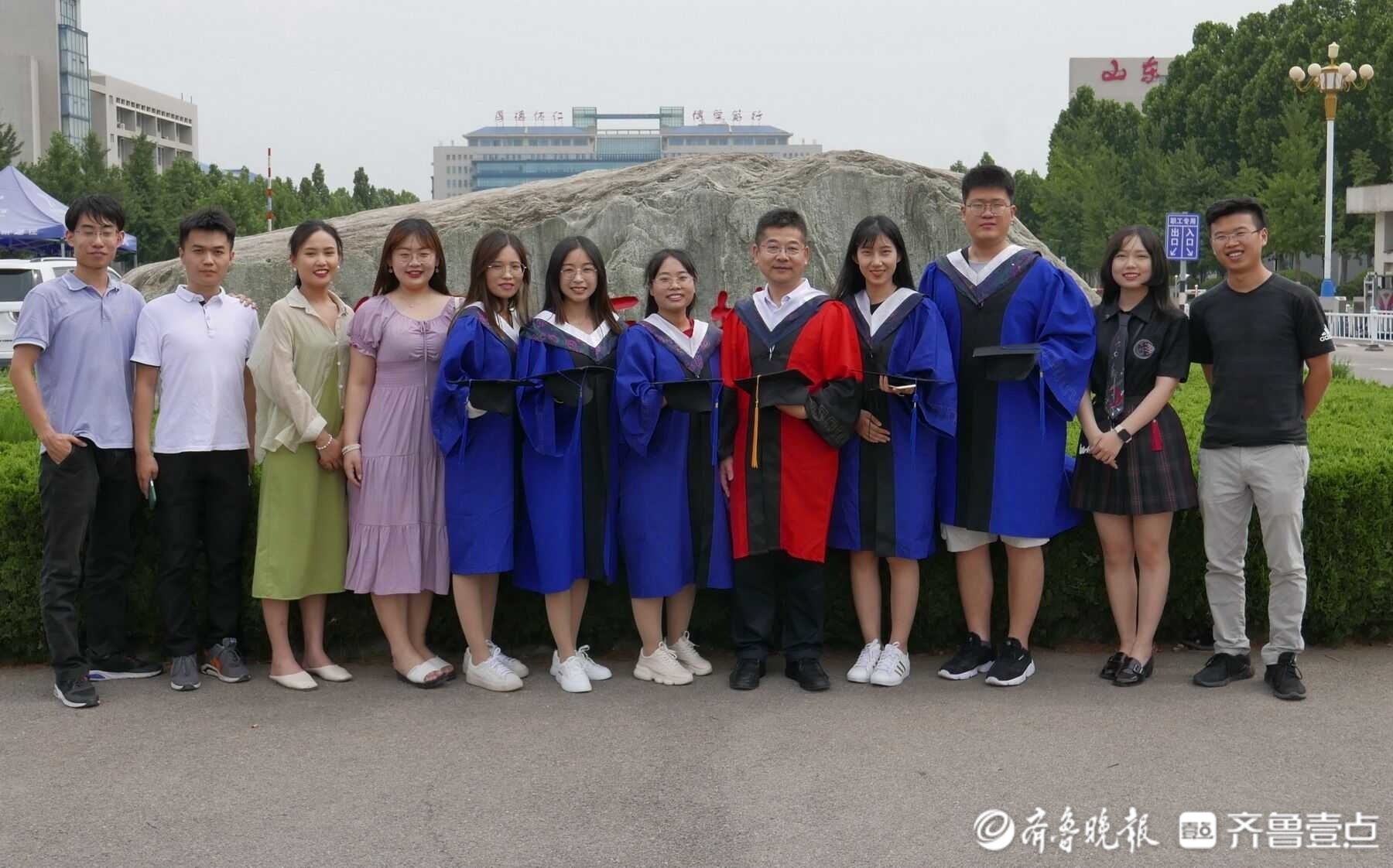 6月24日,山东中医药大学大门口,该校生化专业周教授的毕业生们穿起