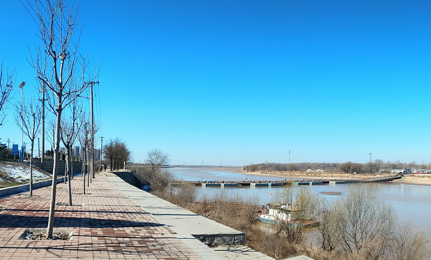 天气晴好,站在黄河大坝上,往东眺望,承载着百年历史的铁路桥静静地