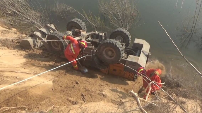 果然视频|疑路面塌陷装载机倒扣河边，消防到场救出被困者