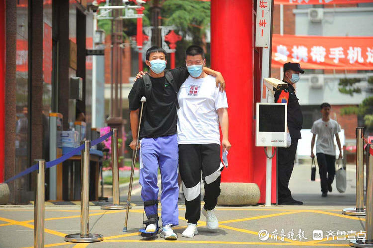 受伤考生在同学的搀扶下走出考场笑容满面