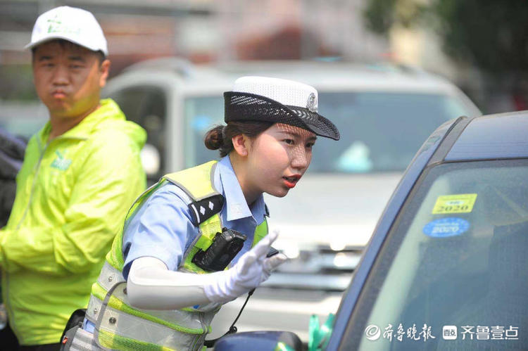 高考考点外女交警烈日下护送考生入场