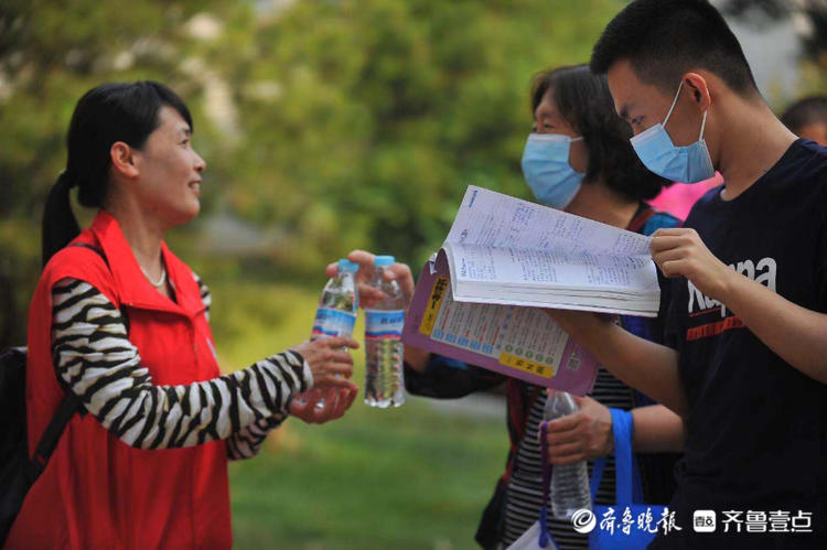 物理考试前考生场外复习爱心人士递上两瓶水