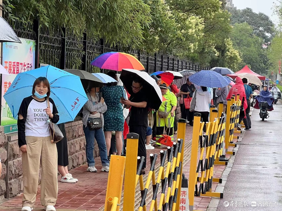 开考后家长不舍离去，屋檐下避雨冷风中候场