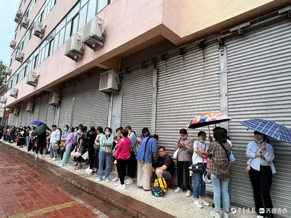 开考后家长不舍离去，屋檐下避雨冷风中候场
