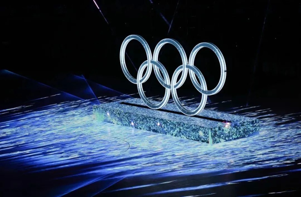 的激光打在冰立方上雕刻出一个晶莹剔透的冰雪五环,音乐声中奥运五环