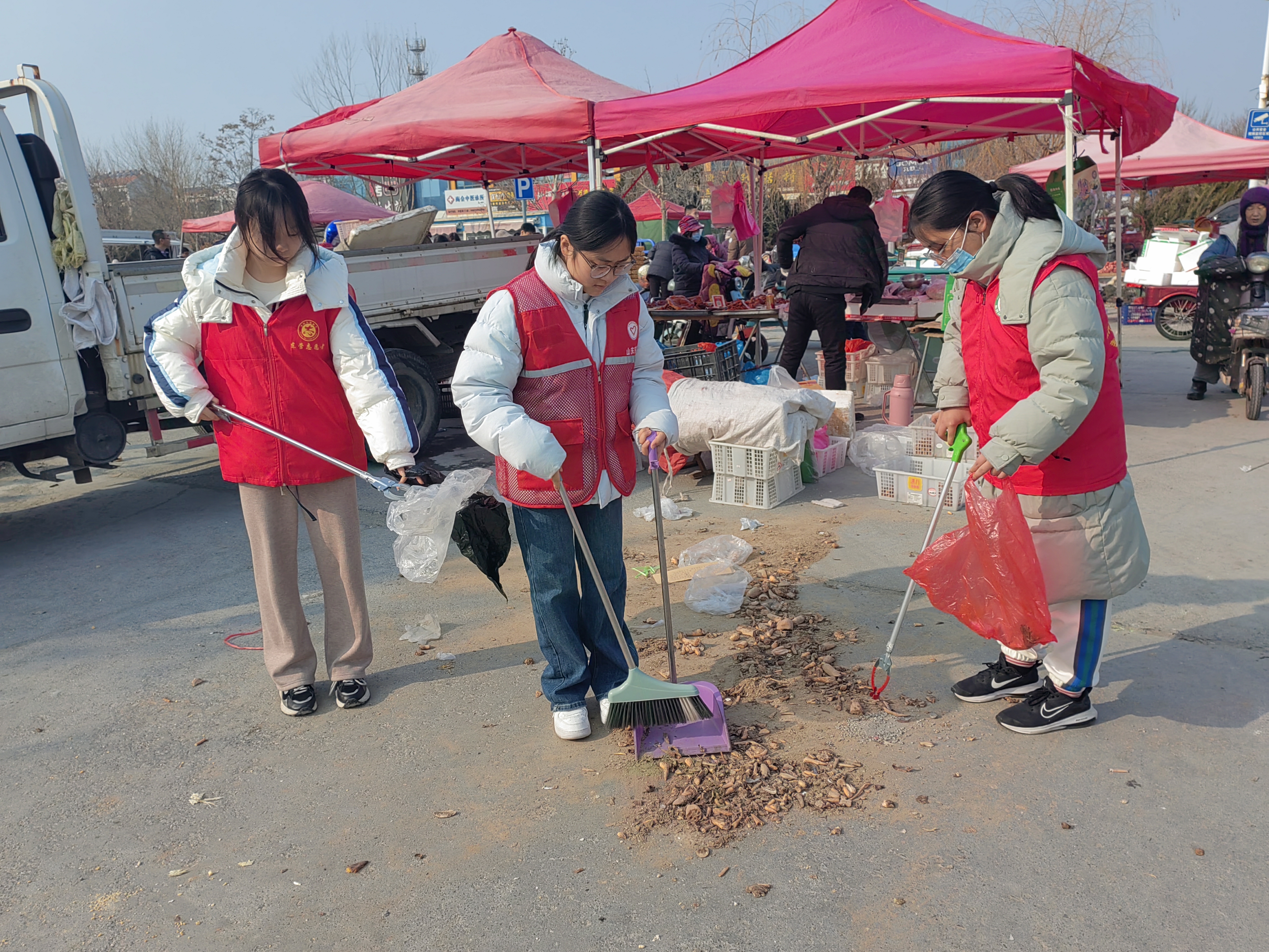 东营区志愿者开展集市大清扫市民喜乐过大年