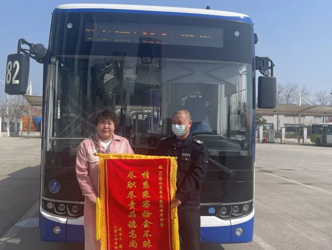 市民迟女士赠送锦旗给82路驾驶员张海岩(右).