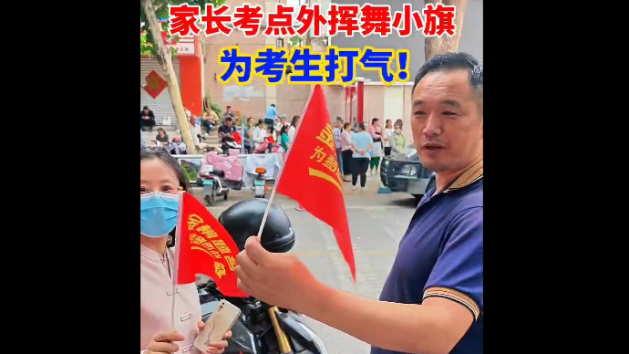 “金榜题名，为梦想而战”，家长考点外挥舞小旗，为考生打气！