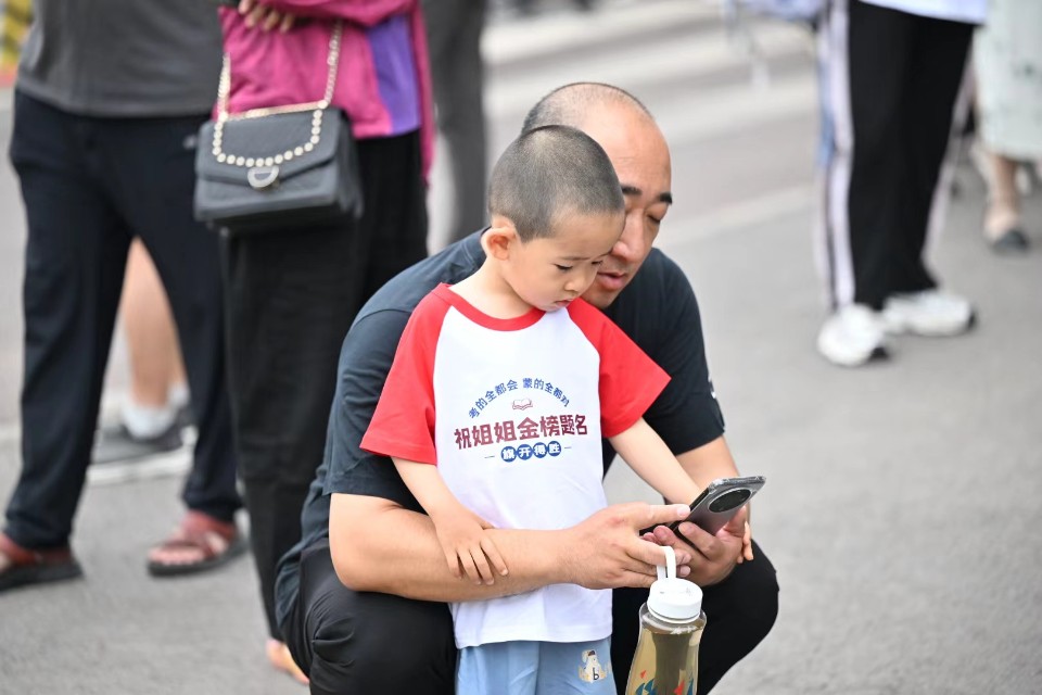 祝姐姐金榜題名！小家伙身穿定制服考場外送祝福