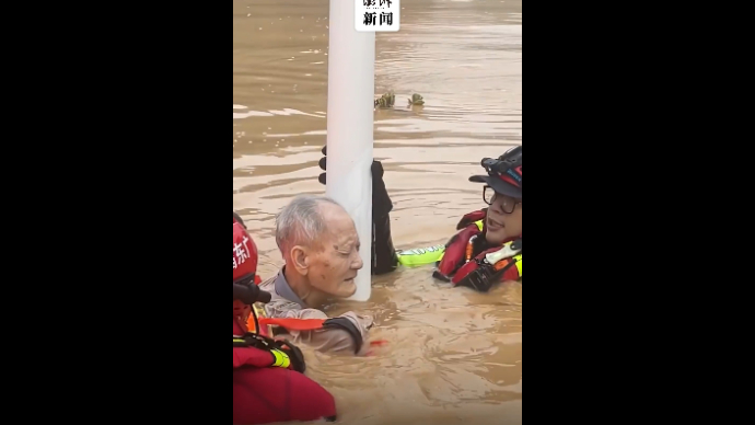 梅州一老人洪水中紧抱路灯被消防员救出