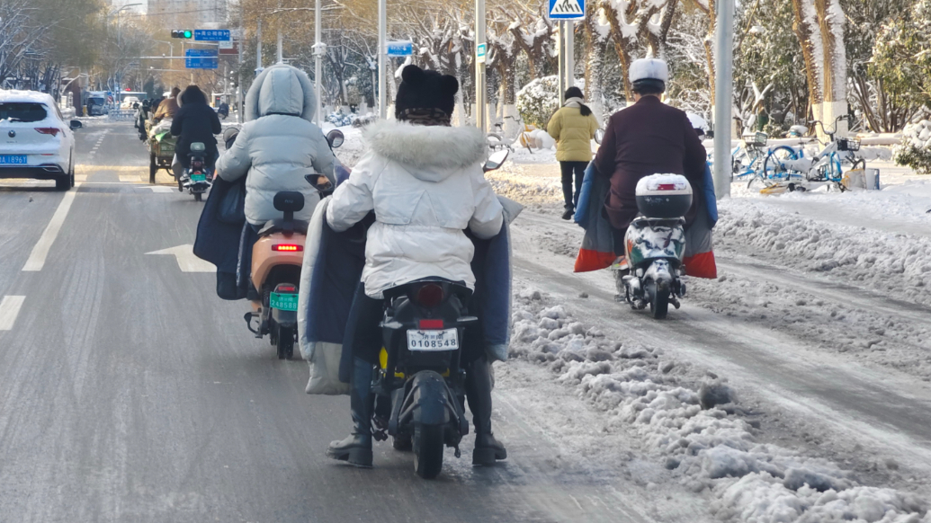 果然视频|济南雪后，骑车上班族小心翼翼谨慎行驶  