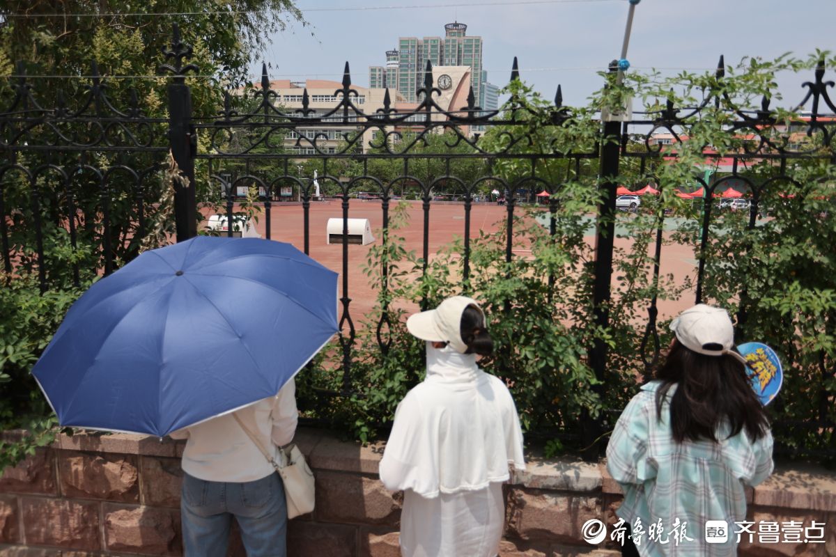 隔栏张望，家长考点外默默加油助威