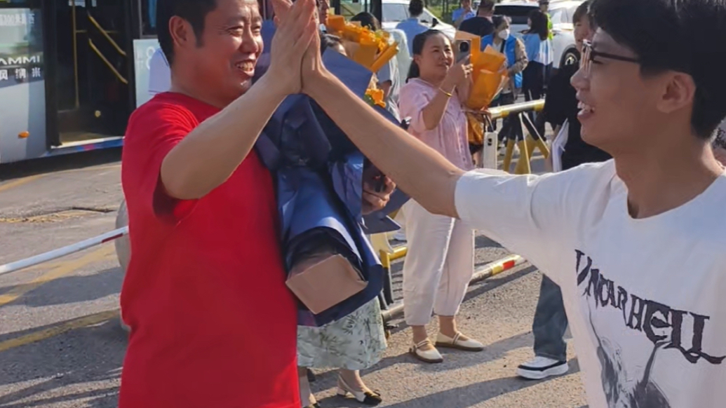 高考结束，惠民二中老师手捧鲜花和学生们击掌庆祝