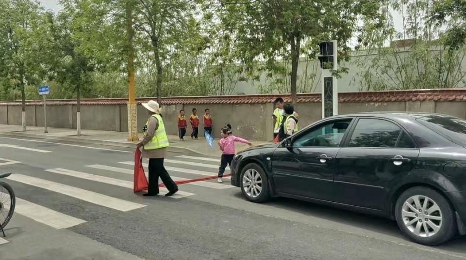 学校附近数名儿童用身体挡车“护学”？当地回应：已约谈学校校长