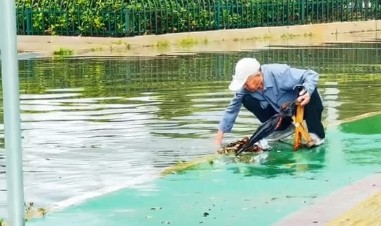 雨后街头感人一幕：积水拦路，菏泽一老人徒手疏通下水道