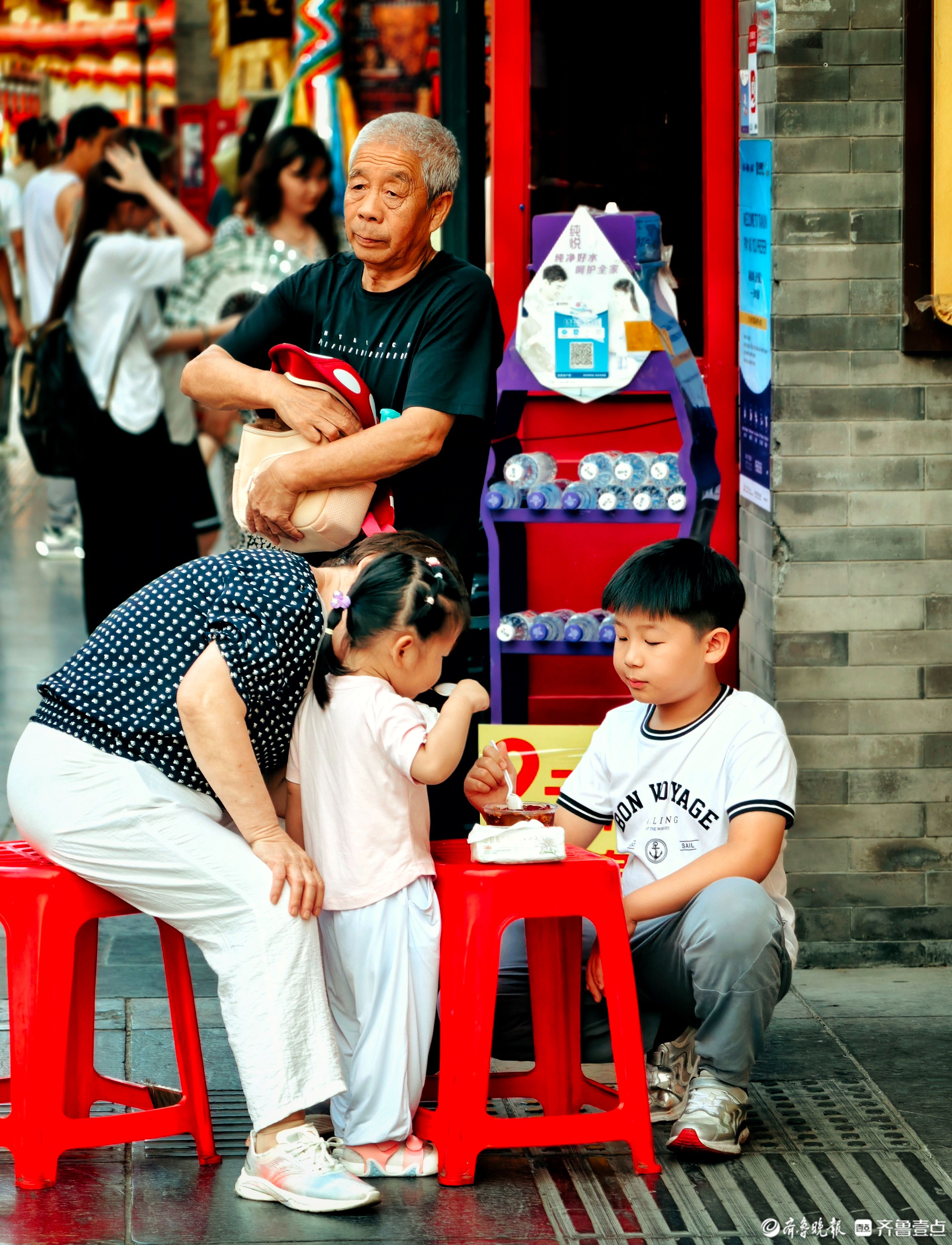 天津古文化街道内，小朋友吃冰淇淋降温