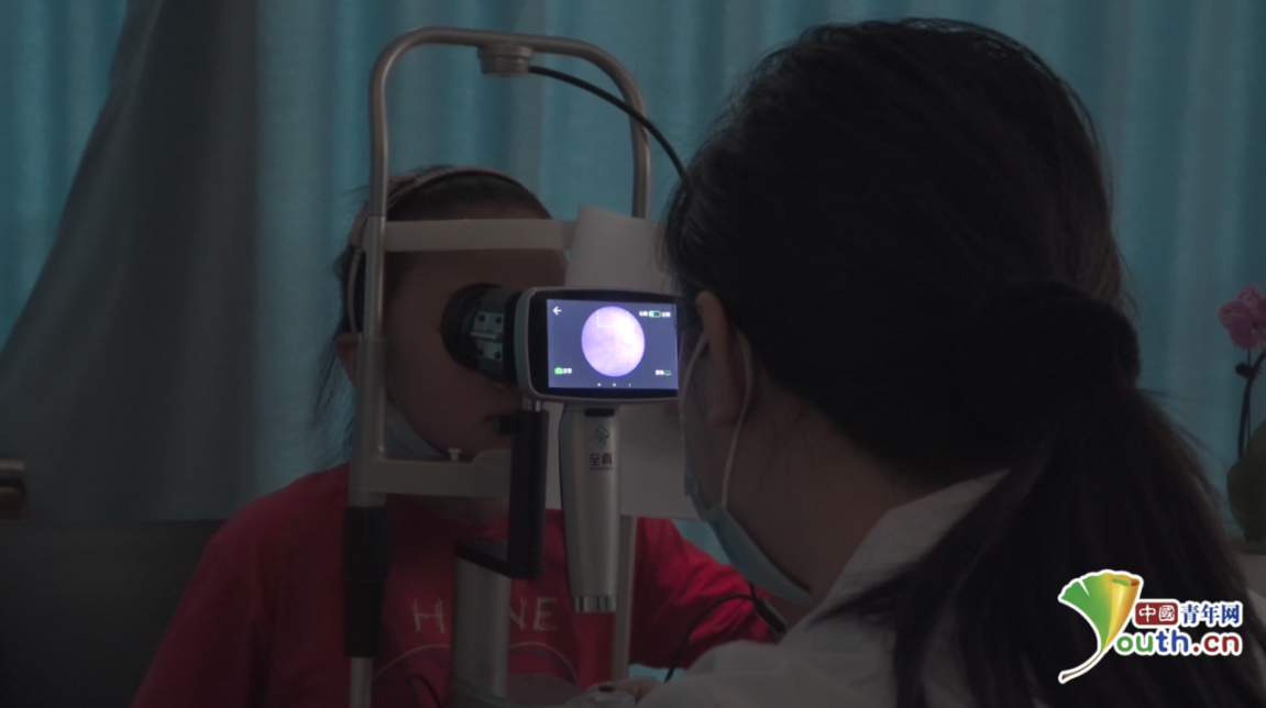 医生正在帮助孩子做眼底筛查.中国青年网记者 宋继祥摄