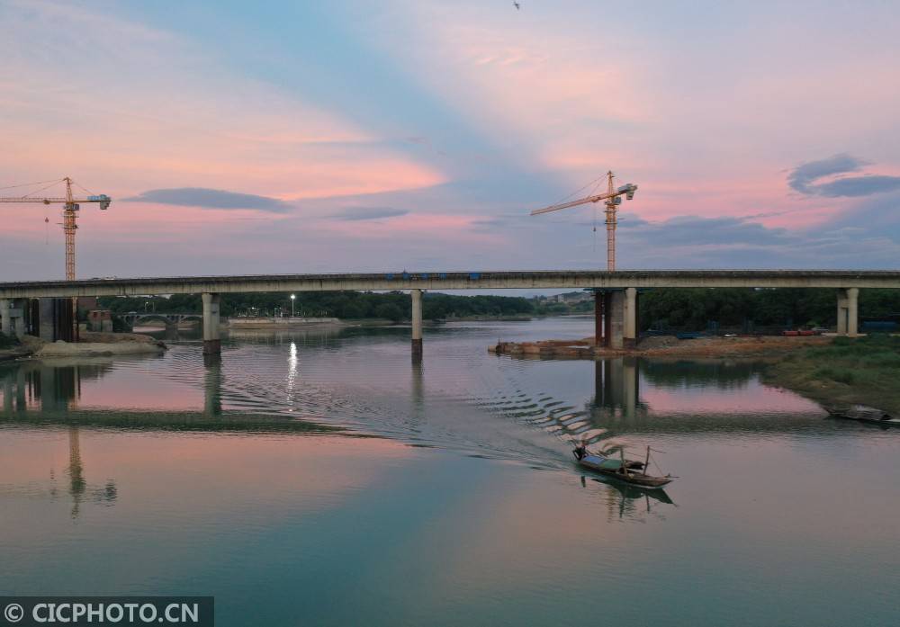 2020年6月18日,在湖南省永州市道县潇水河,一条渔船驶过.