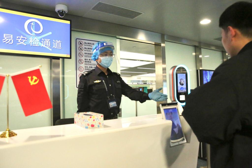 12月21日,旅客张先生在青岛胶东国际机场安检人员的引领下,来到"易