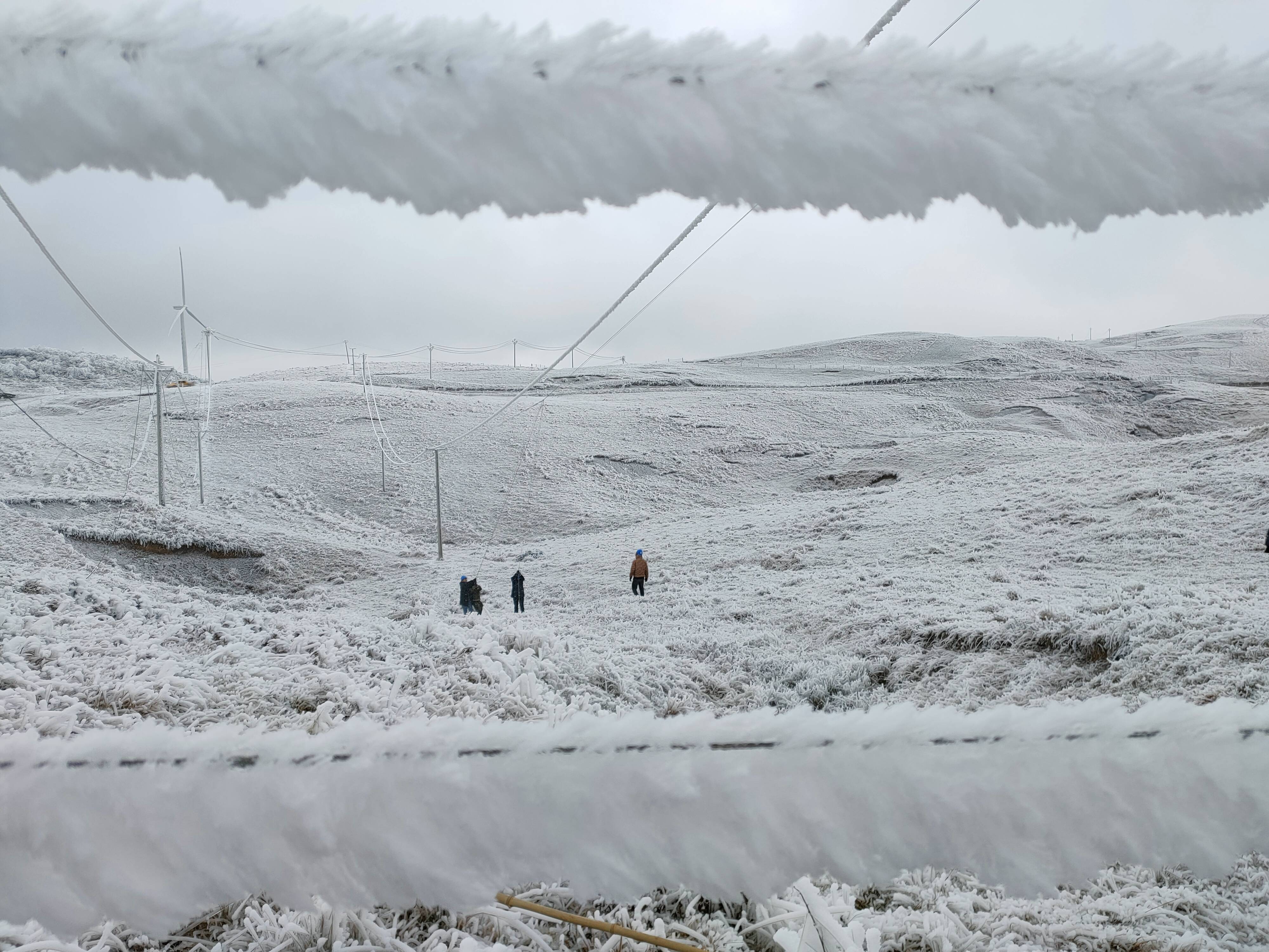 图为电力工人在冰天雪地中巡线 责任编辑