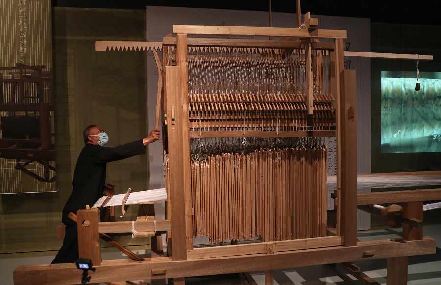 工作人员演示复原的成都老官山汉墓织机.(中国日报记者 邹红 摄)