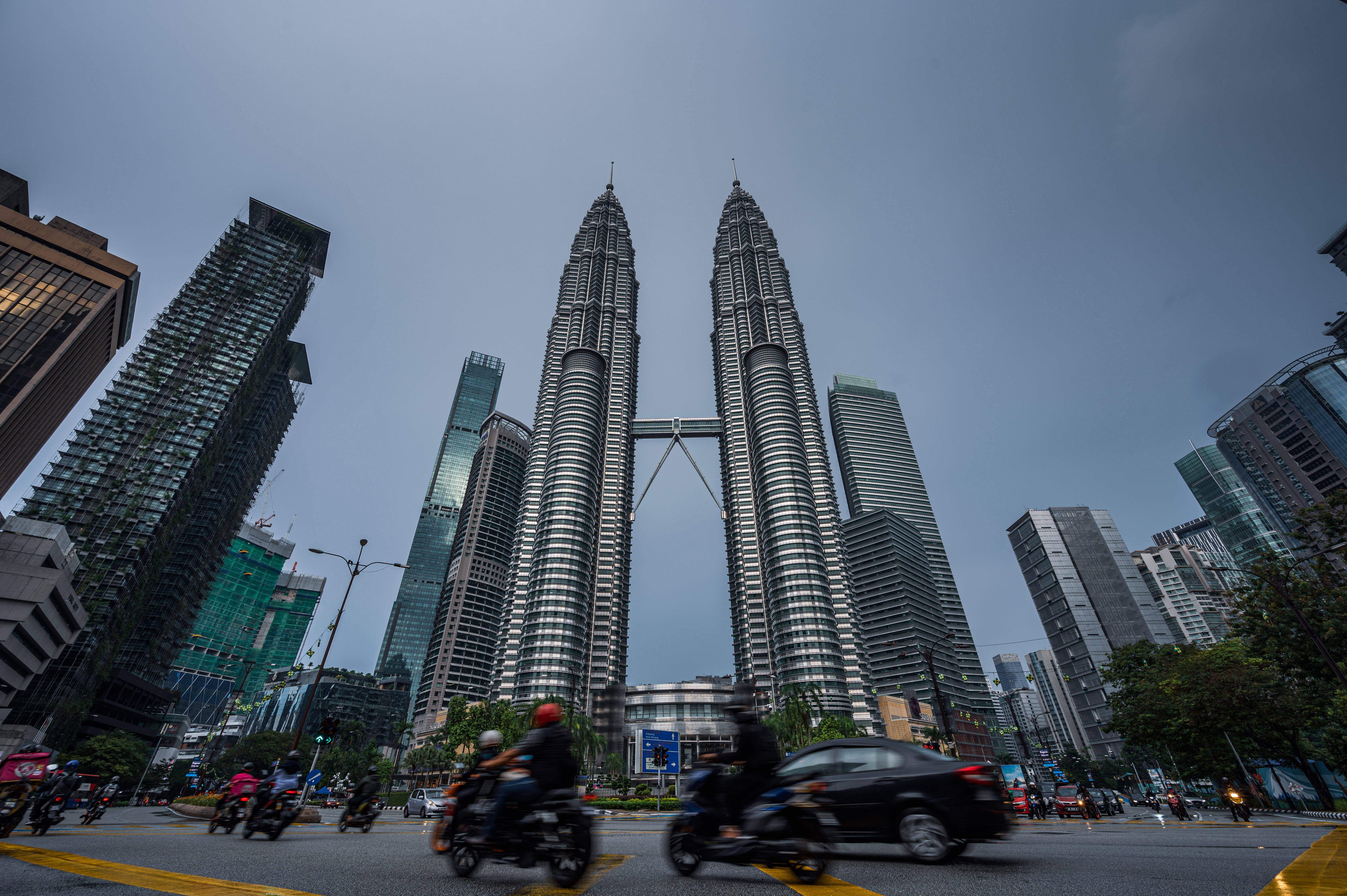5月19日,在马来西亚吉隆坡,车辆从马来西亚国家石油公司双塔前驶过.