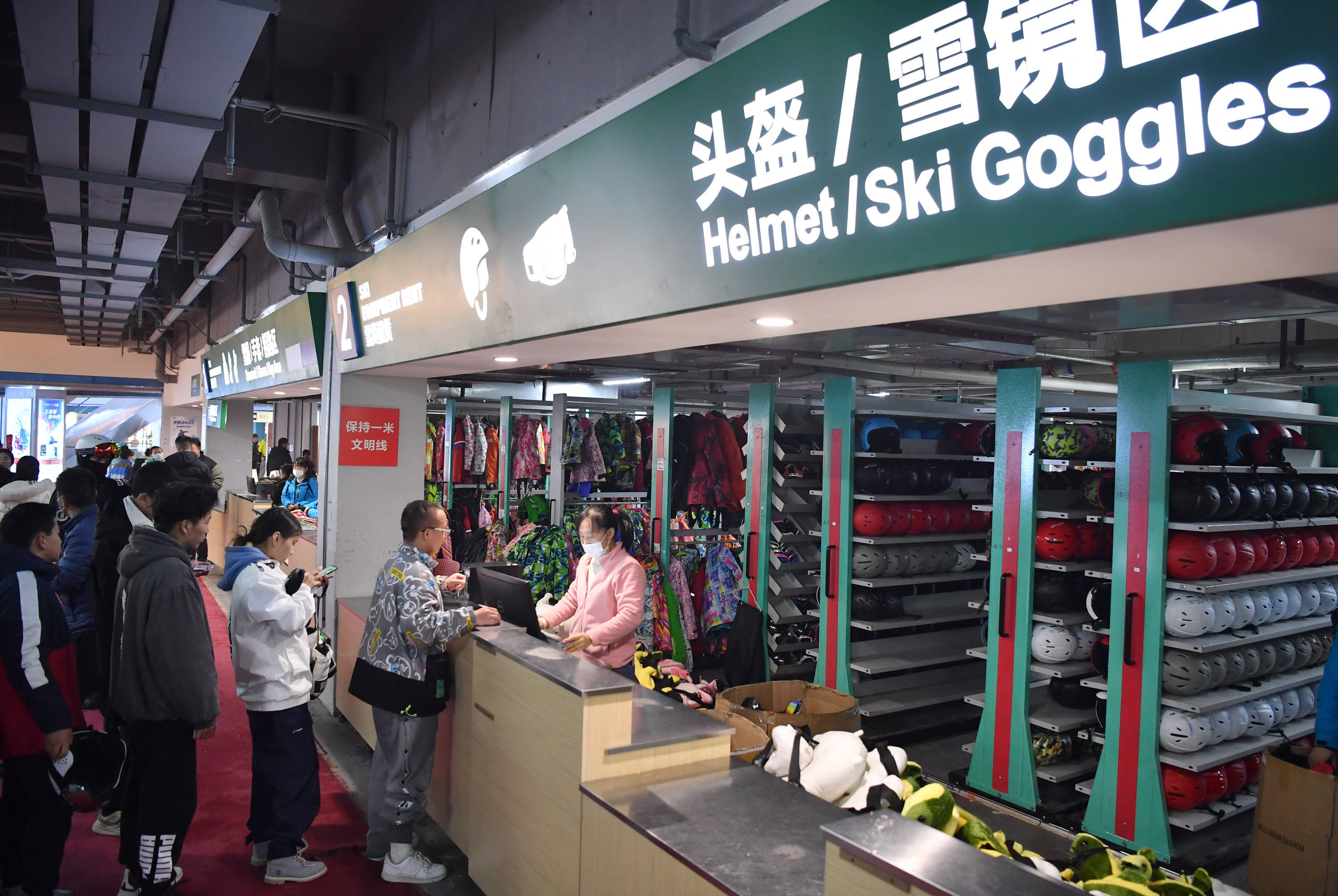 2月14日,游客在鳌山滑雪场雪具大厅内租赁滑雪装备.