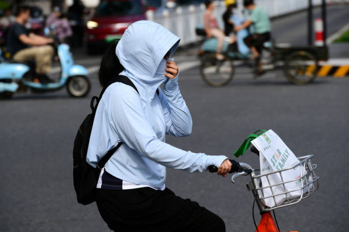 金华高温来袭市民全副武装防晒出行