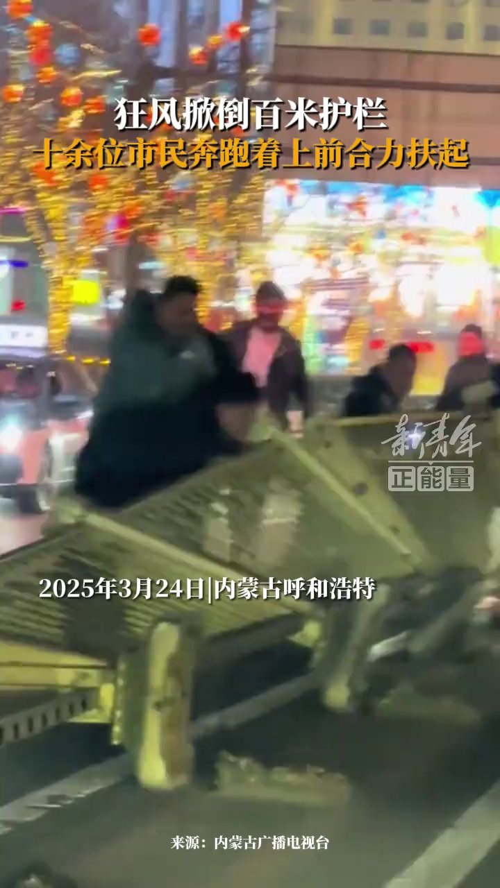 大风将百余米的护栏掀倒在马路上 ，十余位热心市民上前合力扶起护栏