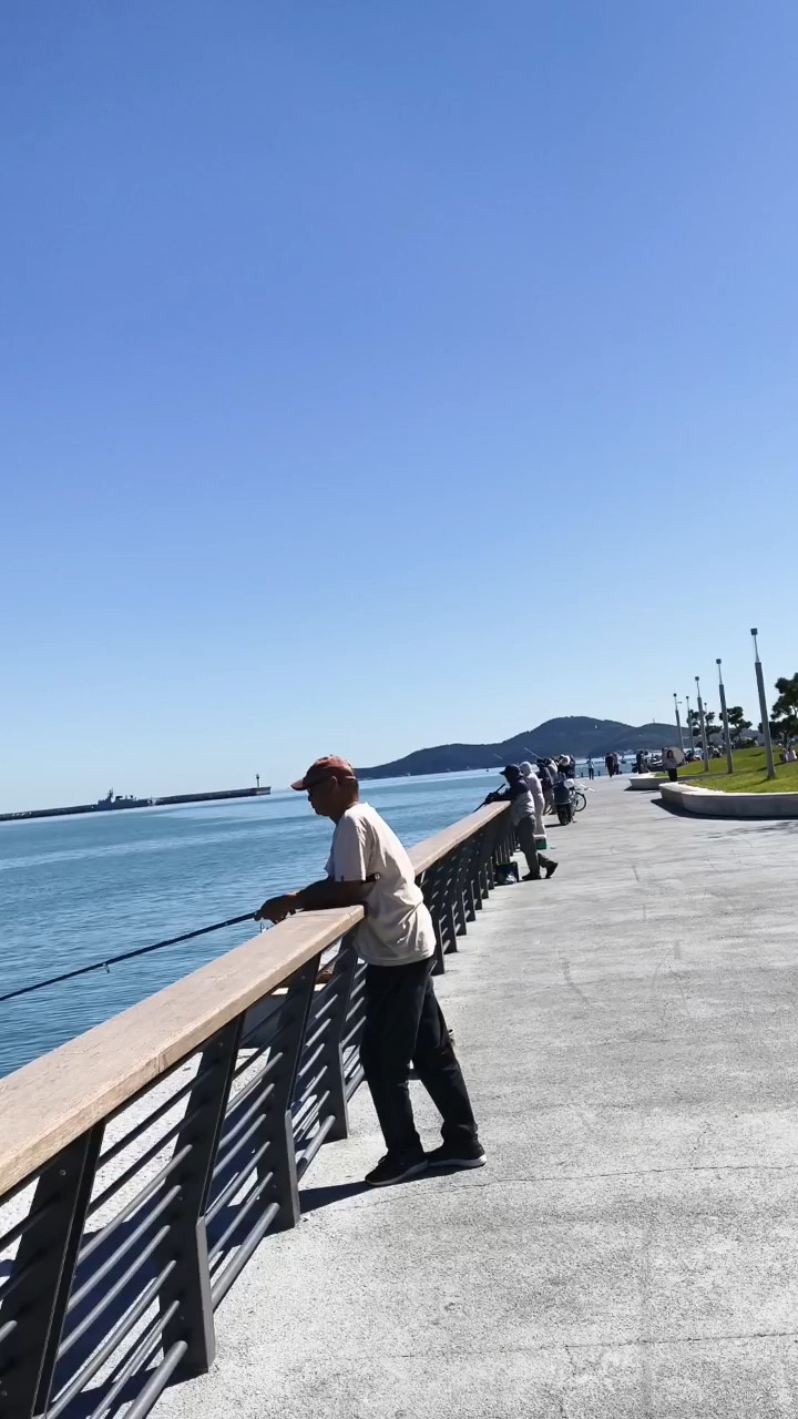至海港湾秋正好，倚栏沐风钓大鱼。