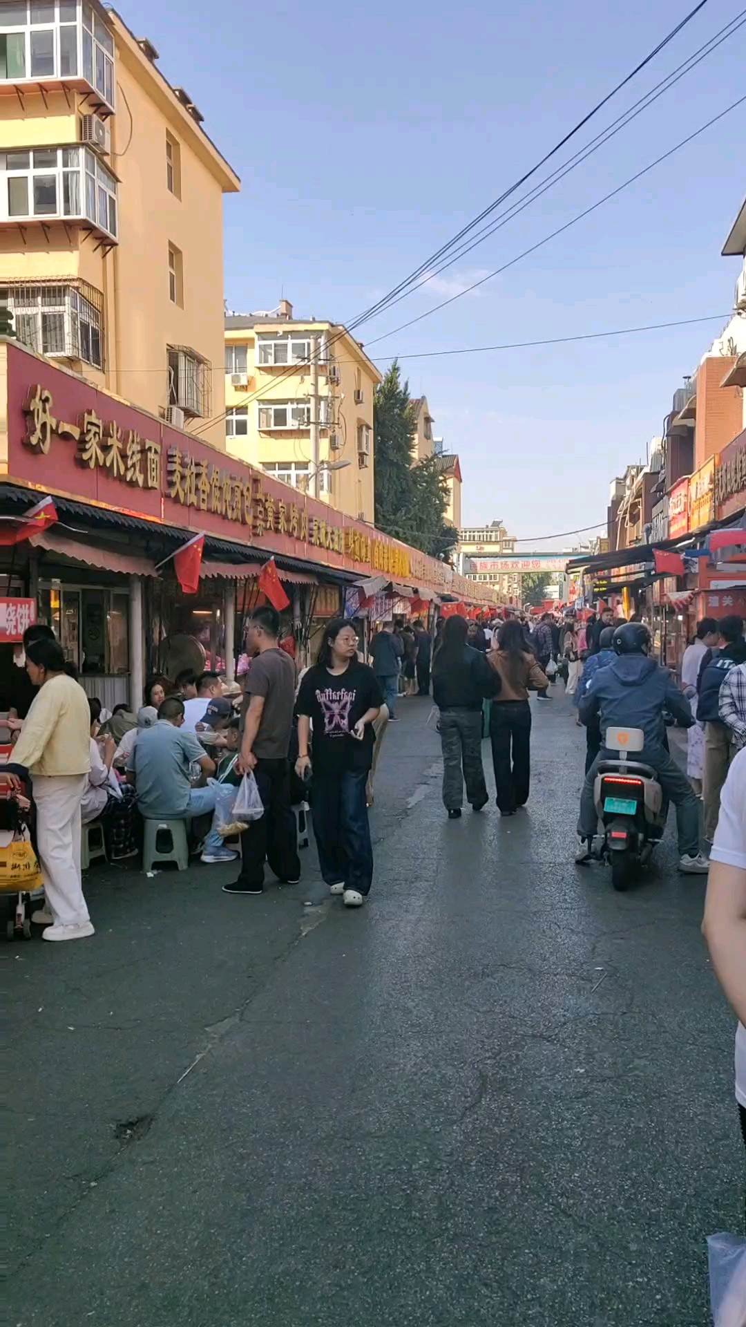国庆假期民族市场格外忙，商铺家家挂上五星红旗。